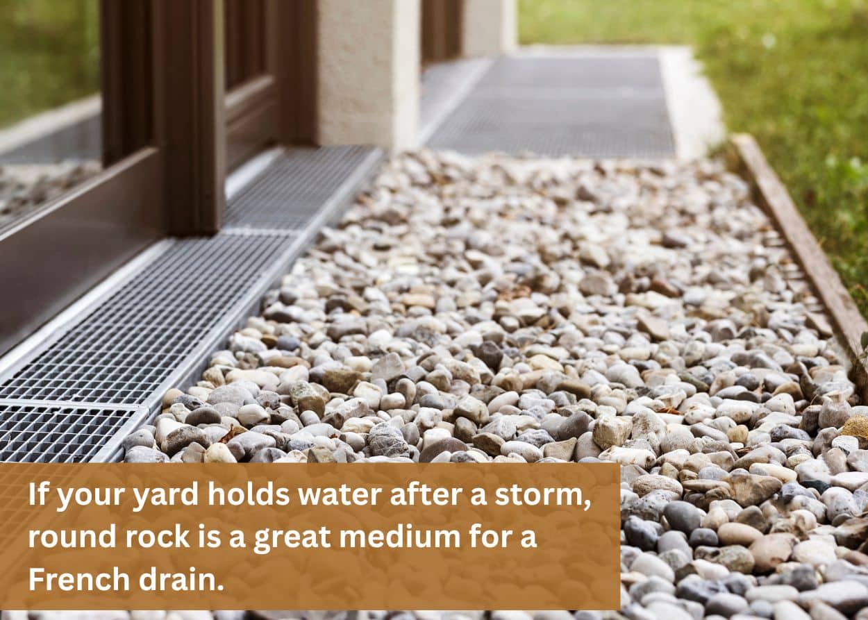 Round river rock installed along a home's foundation for drainage and landscaping.